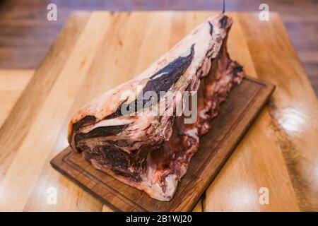 Huge piece of cured beef on a wooden table Stock Photo