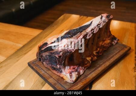 Huge piece of cured ham on a wooden table Stock Photo