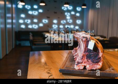 Piece of cured meat with a tag on a wooden table Stock Photo