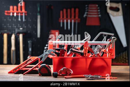 Toolbox With Different Worktools Against Wall With Tools Stock Photo