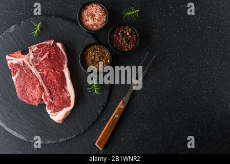 Raw t-bone porterhouse beef steak meat with chimichurri sauce. Stock Photo