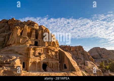 Petra, Jordan. Setting sun light over the Obelisk Tomb or Bab As Siq Triclinium in the beautiful Middle East kingdom. Beautiful clouds in the blue sky warm winter day afternoon Stock Photo