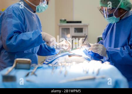 Doctor surgery team in the operating room of abdominal cesarean section during child birth at patient nurse emergency hospital. Stock Photo