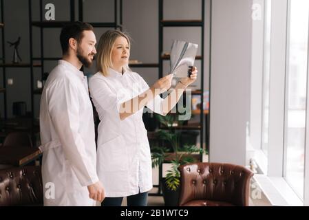 Team of young doctors discuss X-ray of patient in meeting room Stock Photo