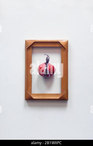 A single red easter egg in the center of the wooden frame on white background. Top view. Easter festive holiday background. Minimalistic photo Stock Photo