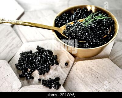 Fresh black caviar on a golden spoon. Tasty appetizer. Stock Photo