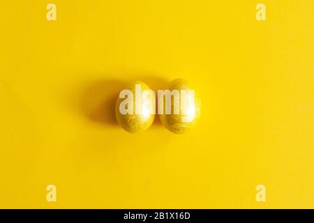 Golden testicles. Easter eggs on yellow. Two eggs on yellow background Stock Photo