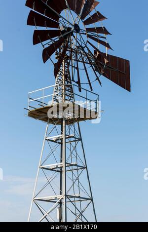 Stationary American or Farmers Windmill against a clear blue sky Stock Photo