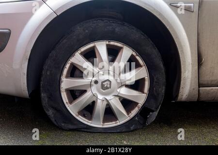 A large hole in the wall of a tyre after a blowout. The rim of the ...
