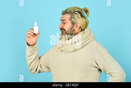 helpful nasal spray. man use nasal drops during course of disease. happy man says no to flu. coronavirus from china. immune system help during epidemic. healthcare in winter. best cold remedy. Stock Photo