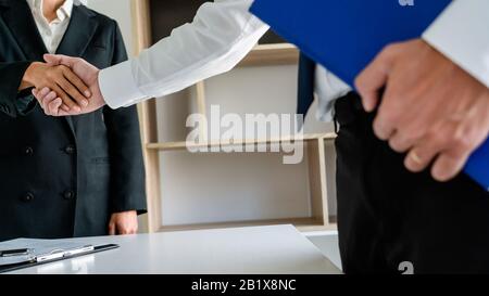 Good deal career and placement concept, successful young businessmen shaking hands after successful negotiation in modern office. Stock Photo