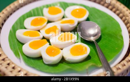 Selective Focused Halved Boiled Chicken Eggs served in green banana leaf tray. Traditional Thai Street Comfort Food, Asian Cuisine, Delicacy, Culture, Stock Photo