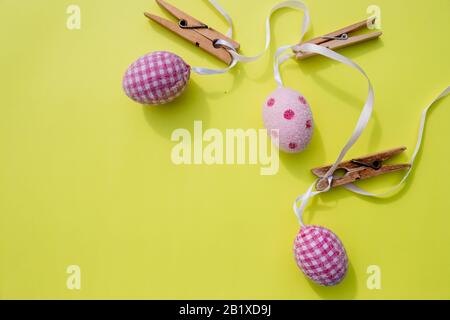 Happy Easter.Greeting card with easter eggs hanging on clothesline, rustic background. Stock Photo