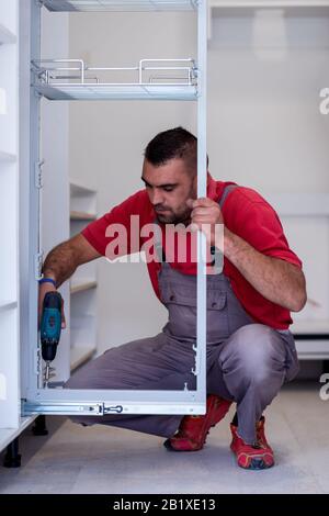 young professional worker installing a new stylish modern kitchen furniture Stock Photo
