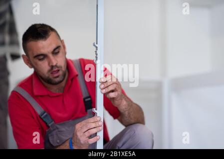 young professional worker installing a new stylish modern kitchen furniture Stock Photo