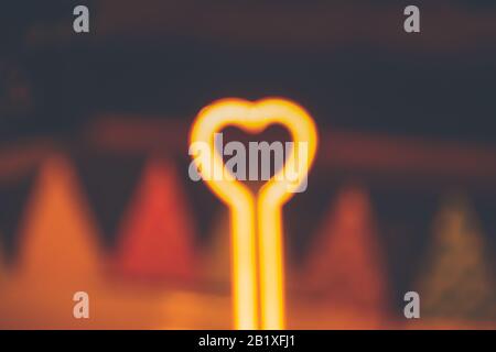 Heart shape neon light that is blurred on purpose to show concept of love, social distancing, self isolation and mental health during the quarantine d Stock Photo