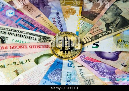 Cryptocurrency conceptual image of bitcoin internationalism and safety. Security currency bitcoin Physical coin bitcoin on the banknotes of different Stock Photo