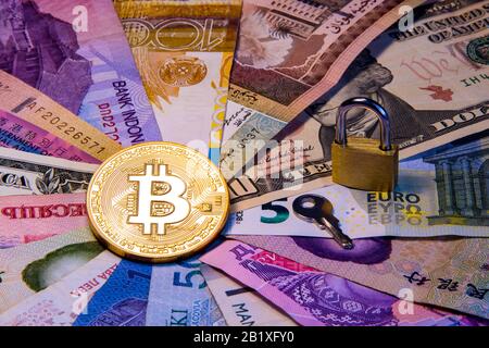 Cryptocurrency conceptual image of bitcoin internationalism and safety. Security currency bitcoin Physical coin bitcoin on the banknotes of different Stock Photo