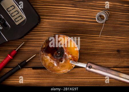 Set for soldering wire and shrink soldering tube with solder next to screwdriver and multimeter on a wooden background Stock Photo