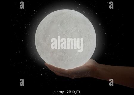 The moon hold by a human hand. Stock Photo