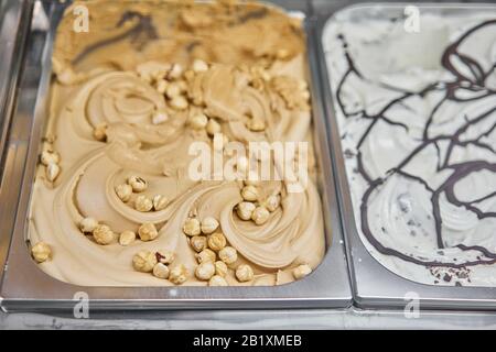 Walnut and hazelnut Gelato. Flavors various ice cream in Rome, Italy. Italian gelateria. Assortment of colorful gelato on cafe showcase. Natural fresh Stock Photo