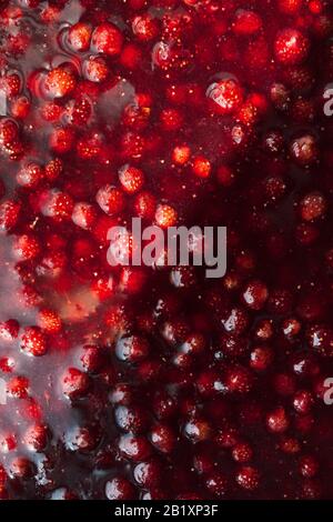 strawberry jam texture divided in half by a solar flare, food background vertical Stock Photo