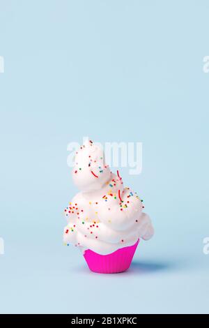 Bright pink cupcake case and barbershop shaving foam as cream on pastel blue background. Creative minimal summer barber skincare bodycare concept. Adv Stock Photo