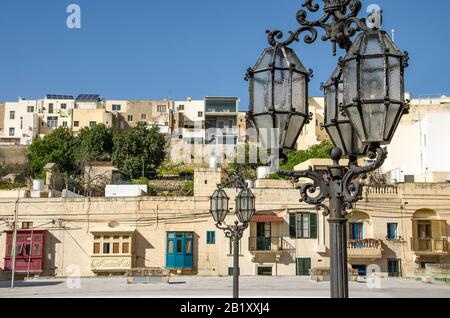 Stylish wroght iron street lamp with blue sky and traditional Maltese architecture Stock Photo