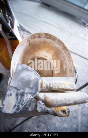 Top view of construction tools in bucket on concrete background. Set of assorted plaster trowel tools and spatula Stock Photo