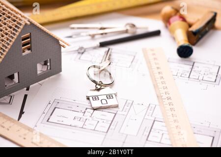 A model house on blueprints with keys to the new home Close up Stock Photo