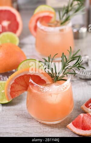 Cocktail pink Palomas fresh lime and rosemary combined with fresh grapefruit juice and tequila. A festive drink is ideal for brunch, parties and holid