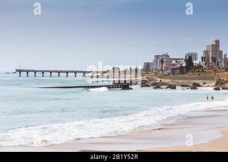 PORT ELIZABETH, SOUTH AFRICA - FEBRUARY 01 2020: View taken from Humewood beach towards Hobie beach with Shark Rock Pier, buildings and restaurants in Stock Photo