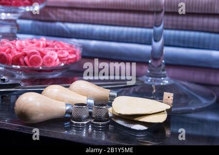 Tailor's Table with Assorted Implements including awl, thimbles, buttons and chalk Stock Photo