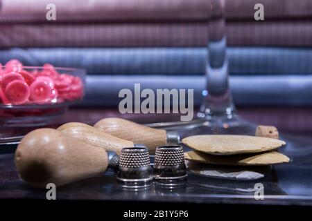 Tailor's Table with Assorted Implements including awl, thimbles, buttons and chalk Stock Photo