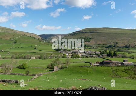 Summer view of the Yorkshire Dales village of Muker in Swaledale surrounded by a classic Yorkshire landscape of meadows and moors Stock Photo