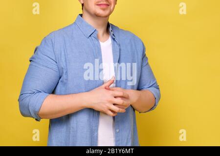 A man in a shirt on a yellow background stands idly by. Close up. Stock Photo