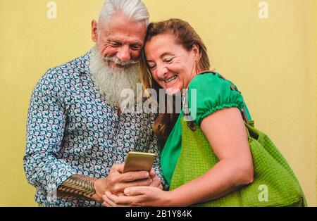 Senior couple using smartphone - Mature people having fun with new trends technology - Tech and joyful elderly lifestyle concept - Main focus on man f Stock Photo