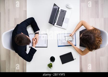 Directly Above Shot Of Young Businesswoman Interviewing Male Candidate In Office Stock Photo