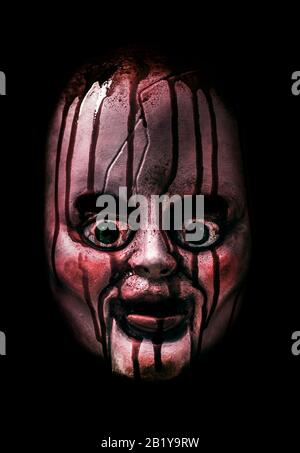Creepy bloody doll head in the dark Stock Photo