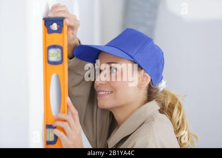 female builder using spirit level Stock Photo