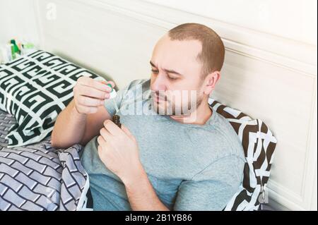 A man has a cold and is lying in bed Stock Photo