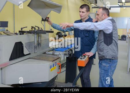 engineer training apprentices on cnc machine Stock Photo