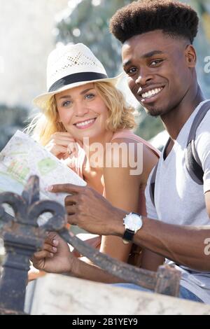 portrait of multi-ethnic couple holding tourist map Stock Photo