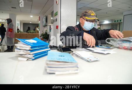 (200228) -- WUHAN, Feb. 28, 2020 (Xinhua) -- Feng Feng, a community worker of grid-based health management, gets medicines for the sick residents of Huiminyuan Community, at the chain store of Hankou pharmacy in Huangshi Road of Wuhan, central China's Hubei Province, Feb. 27, 2020. This chain store of Hankou pharmacy is a designated pharmacy for medicines against chronic serious diseases. The staff members here often have to work from early morning to late night to meet the demand, dispensing an average of 1,000 orders comprising 30,000 packs of medicines each staff member per day. (Xinhua/Cai Stock Photo