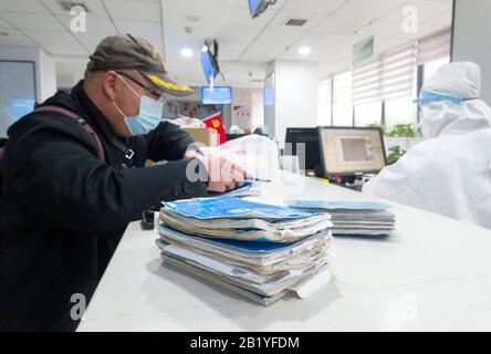 (200228) -- WUHAN, Feb. 28, 2020 (Xinhua) -- Feng Feng (L), a community worker of grid-based health management, gets medicines for the sick residents of Huiminyuan Community, at the chain store of Hankou pharmacy in Huangshi Road of Wuhan, central China's Hubei Province, Feb. 27, 2020. This chain store of Hankou pharmacy is a designated pharmacy for medicines against chronic serious diseases. The staff members here often have to work from early morning to late night to meet the demand, dispensing an average of 1,000 orders comprising 30,000 packs of medicines each staff member per day. (Xinhua Stock Photo