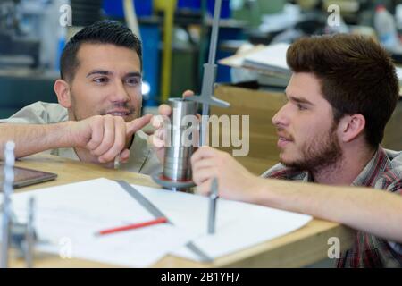 two worker shaping metal in workshop Stock Photo
