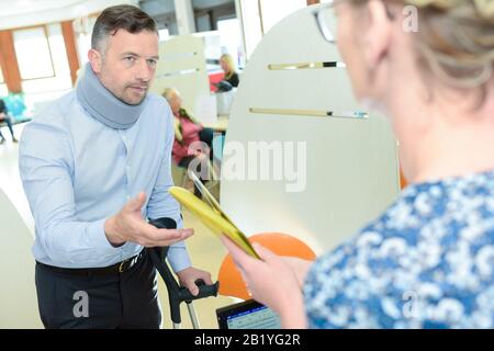 businessman wearing neck brace with crutches Stock Photo