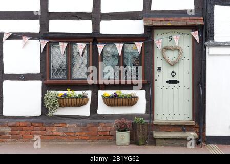 Union jack bunting and weaved heart on a wooden front door on Tudor style Housing in Upton upon Severn Stock Photo