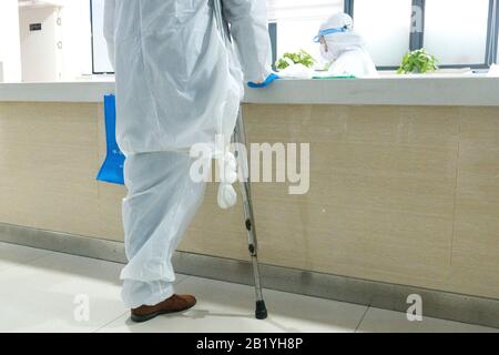 (200228) -- WUHAN, Feb. 28, 2020 (Xinhua) -- Physically disabled Yu Guoqiao handles medicine-taking procedures for a community's disabled patients at a drug store in Wuhan, central China's Hubei Province, Feb. 27, 2020. Yu Guoqiao is a facilitator of a disabled people group at a community in Hanyang District of the coronavirus-hit Wuhan. Since the outbreak of the virus, Yu has overcome difficulties to insistently take medicines for the community's nearly 300 disabled patients. He said he would stick to his position to continuously serve the disabled. (Xinhua/Cai Yang) Stock Photo