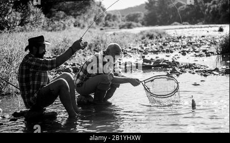 fly fish hobby of men. retirement fishery. Two male friends fishing together. retired father and mature son. happy fishermen friendship. big game fishing. relax on nature. Great day for fishing. Stock Photo